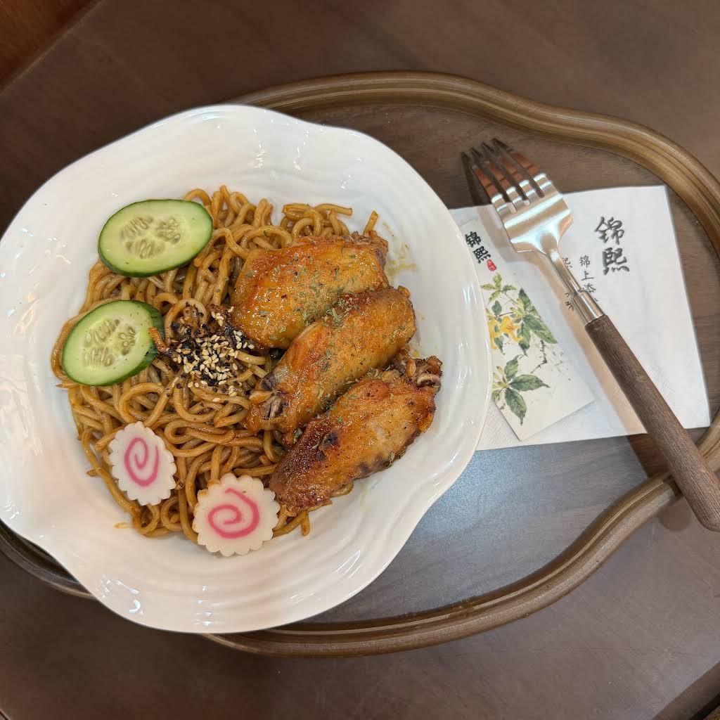 Stirred noodles served with roasted chicken wings